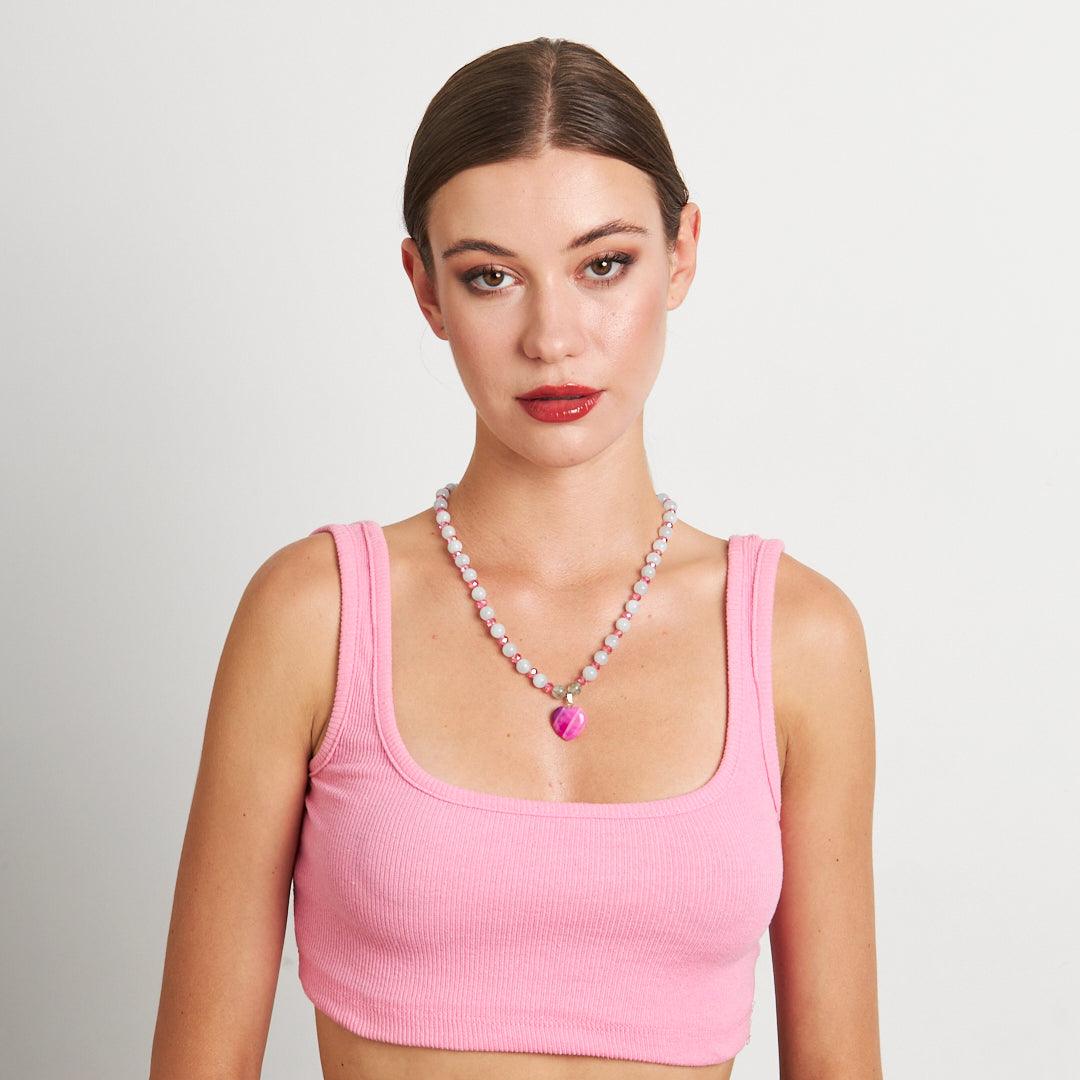 A handcrafted necklace featuring a pink heart pendant with white and pink beaded chain, perfect for adding a touch of elegance to any outfit