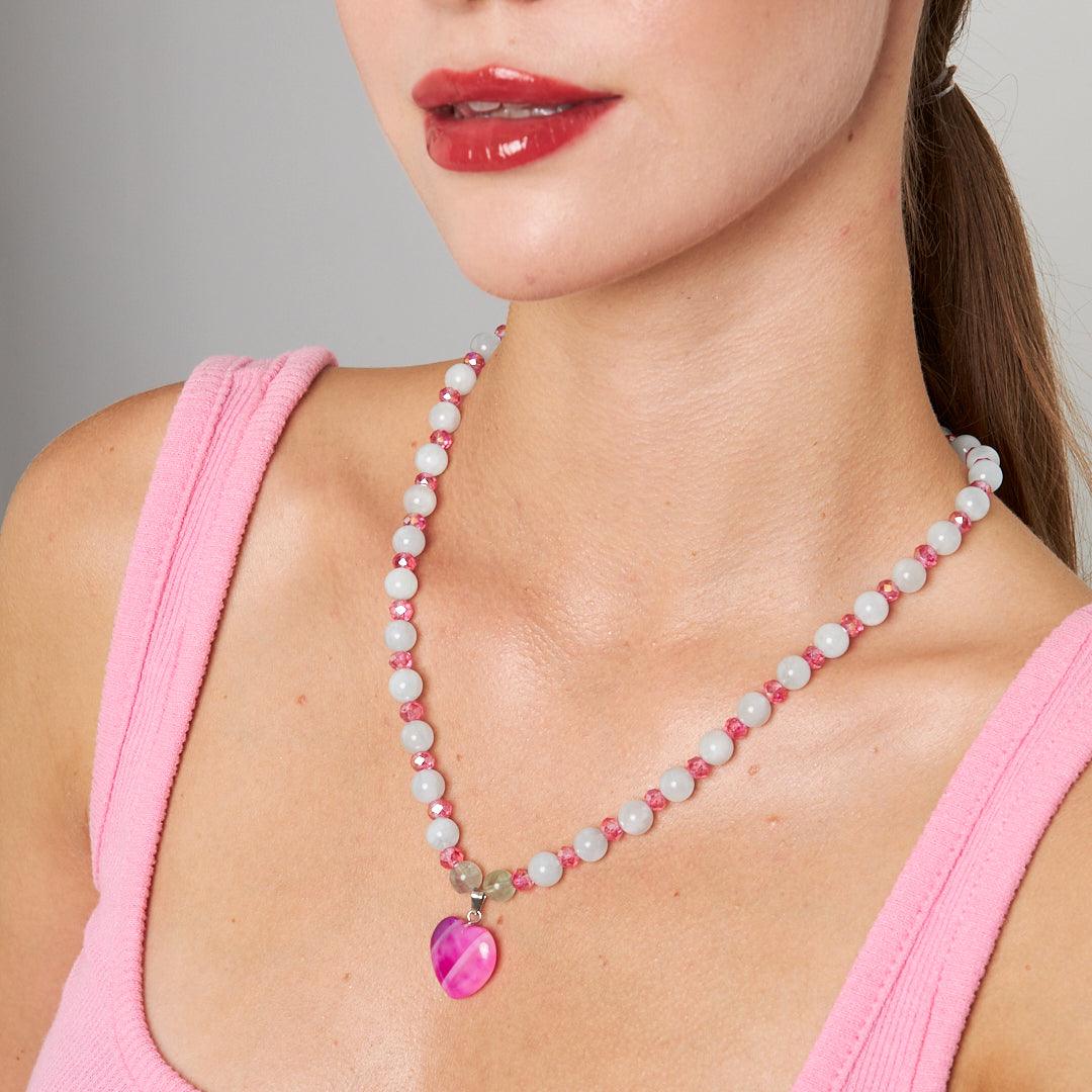 A handcrafted necklace featuring a pink heart pendant with white and pink beaded chain, perfect for adding a touch of elegance to any outfit