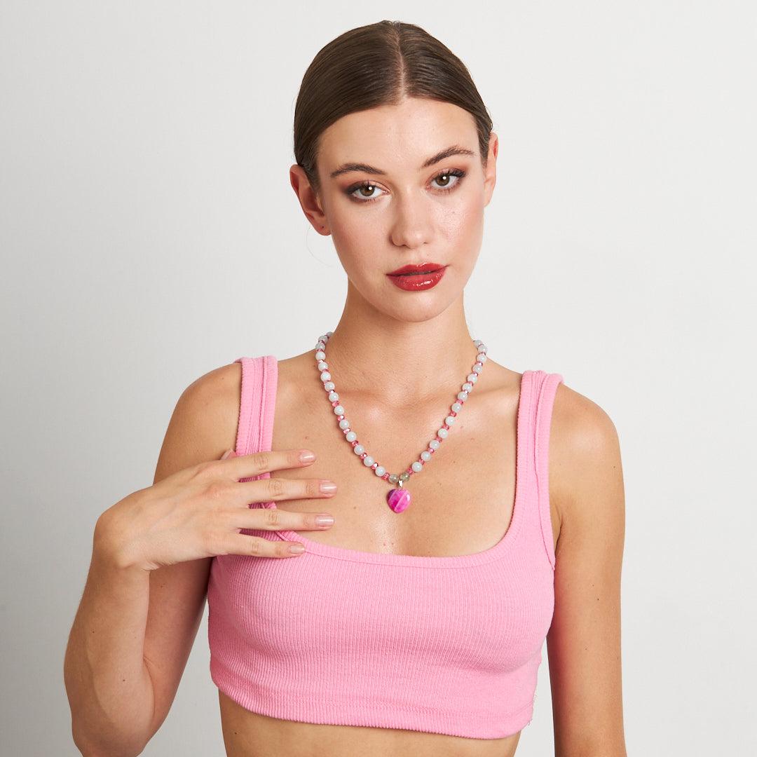 A handcrafted necklace featuring a pink heart pendant with white and pink beaded chain, perfect for adding a touch of elegance to any outfit