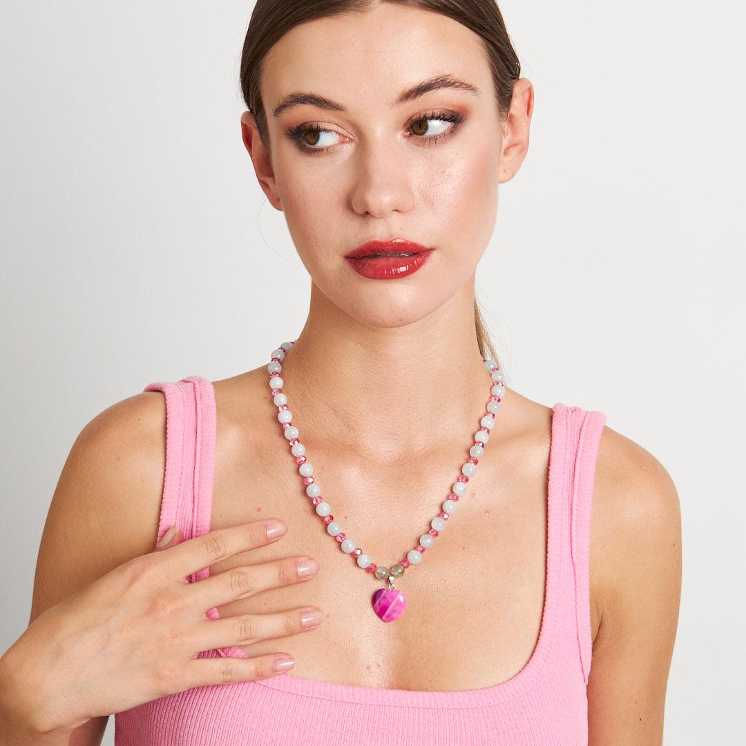 A handcrafted necklace featuring a pink heart pendant with white and pink beaded chain, perfect for adding a touch of elegance to any outfit