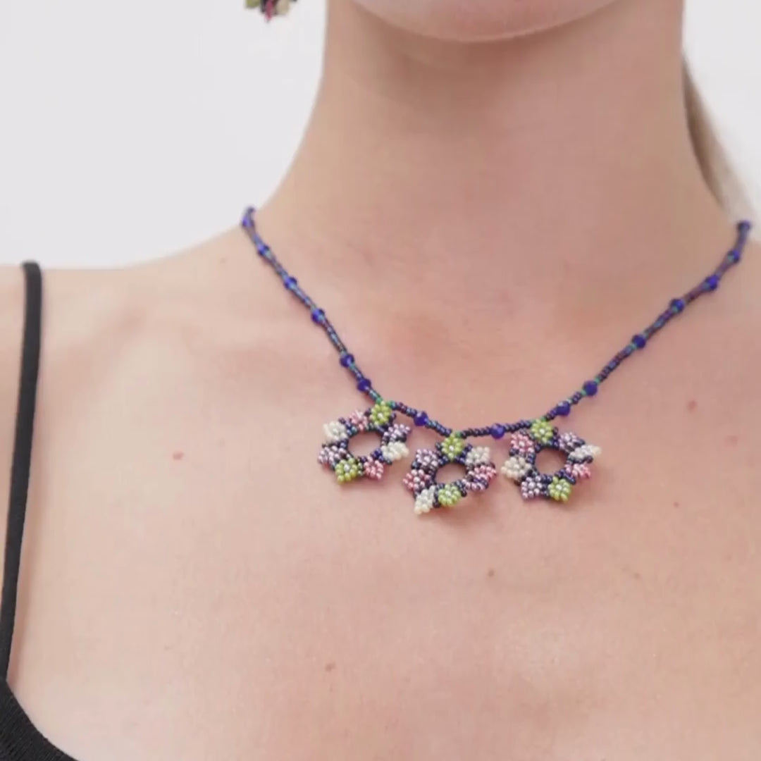 Showcasing a handcrafted seed bead jewelry set featuring an elegant floral design, including a necklace, bracelet, and earrings, perfect for any occasion and highlighting exquisite craftsmanship